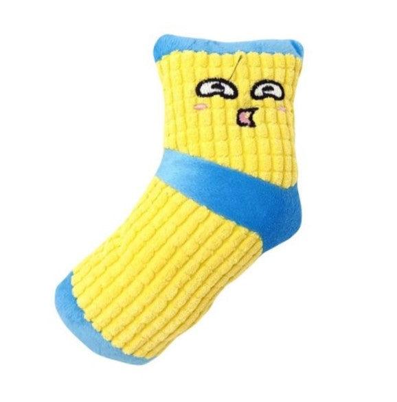 Zacht hondenspeeltje in de vorm van een gele sok met blauwe details en een lachend gezichtje.